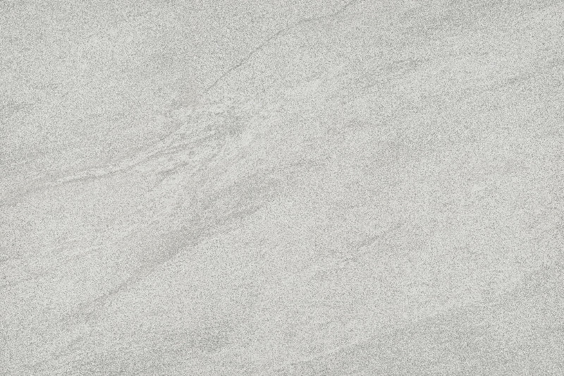 A close-up of a light grey stone or concrete-like surface with subtle natural veining and texture.