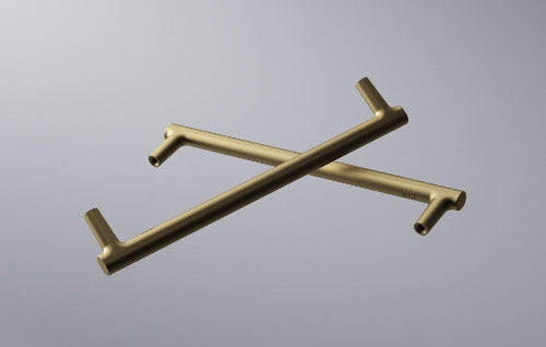 Two gold kitchen towel racks crossed on a gray background