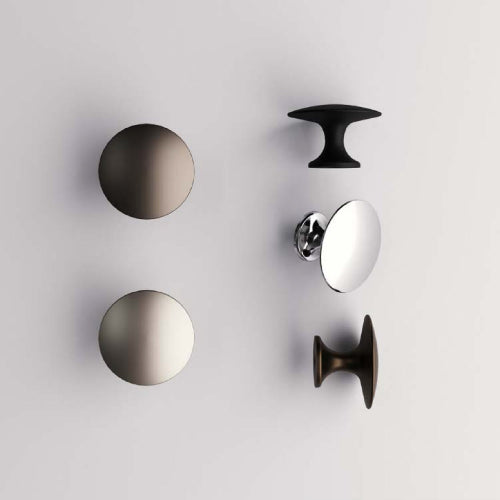 Set of metallic cabinet knobs on a light gray background