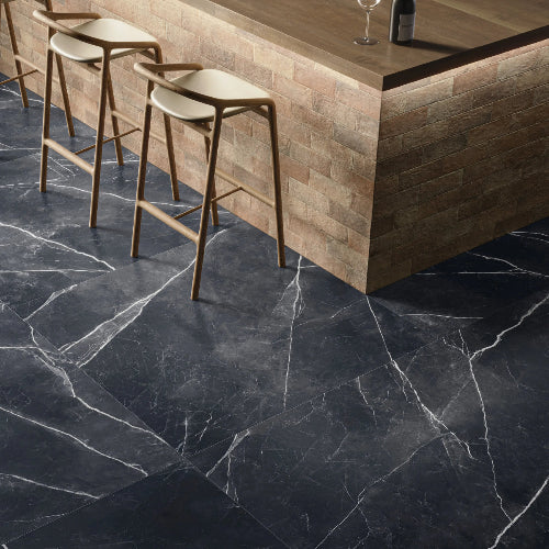 Dark marble floor with wooden bar stools and a bar counter.