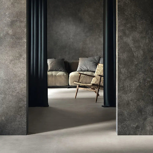 Modern interior with a sofa and chair in a room with gray walls and flooring.