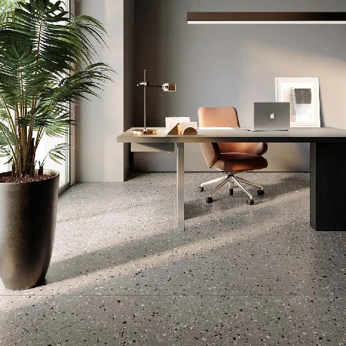 Modern office desk with chair, plant, and decor in a well-lit room.