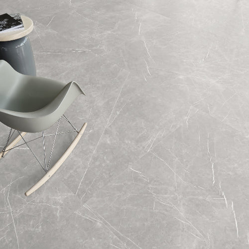 A grey marble effect floor tile with a chair and a side table on a gray marble effect floor.