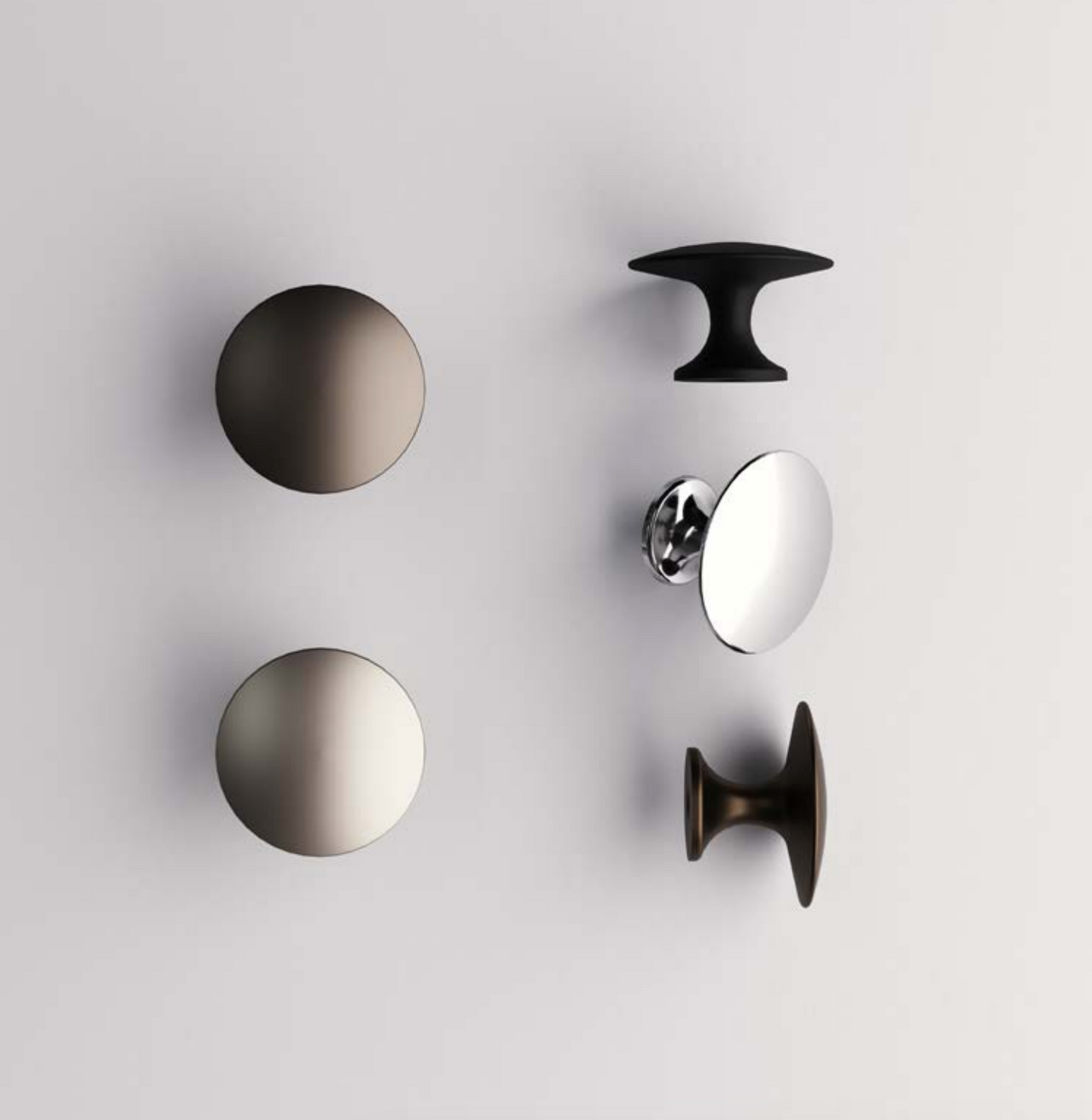 Set of metallic cabinet knobs on a light gray background