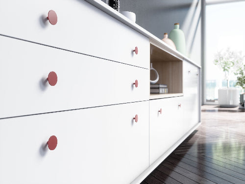White dresser with brushed brass knobs in a modern room setting