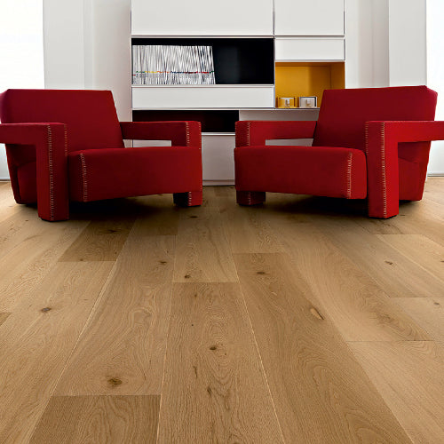 Two red armchairs in a modern living room with wooden flooring.