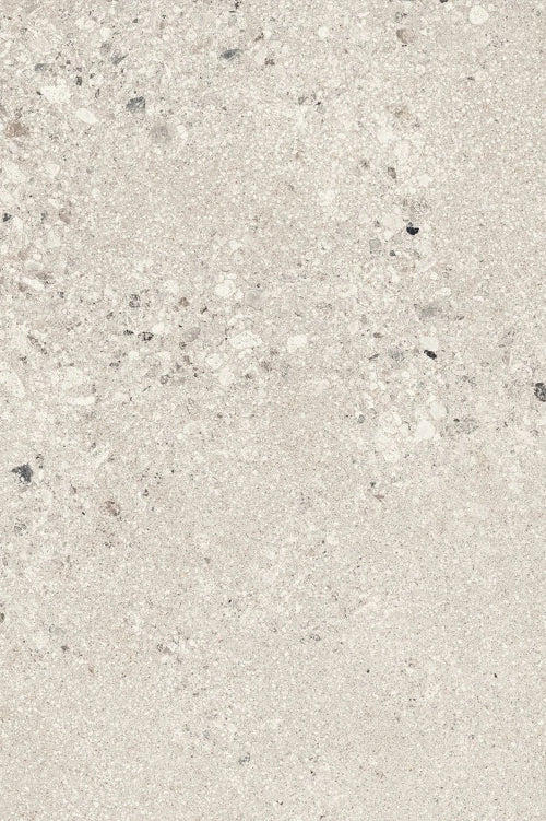 Close-up texture of large pearl-toned gravel aggregate, featuring coarse stone fragments in white, light gray, and dark gray tones with visible angular and rounded particle shapes against a pale background.