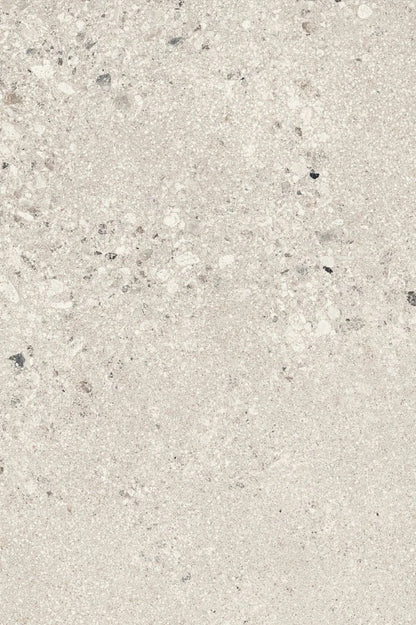Close-up texture of large pearl-toned gravel aggregate, featuring coarse stone fragments in white, light gray, and dark gray tones with visible angular and rounded particle shapes against a pale background.