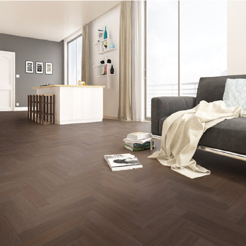 Modern living room with dark wooden floor, gray sofa, and white walls.