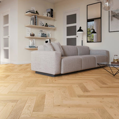 Modern living room with a gray sofa, wooden floor, and shelves.