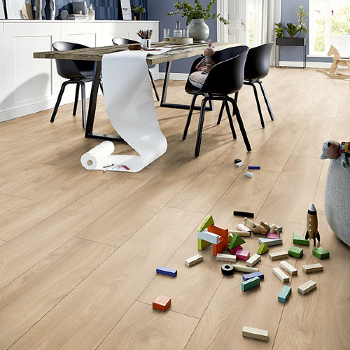 Wooden floor with children's toys and a dining table in the background