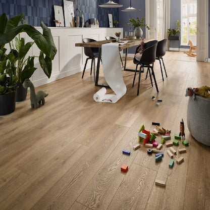 Wooden floor with toys and a roll of paper in a room with a dining table and chairs.