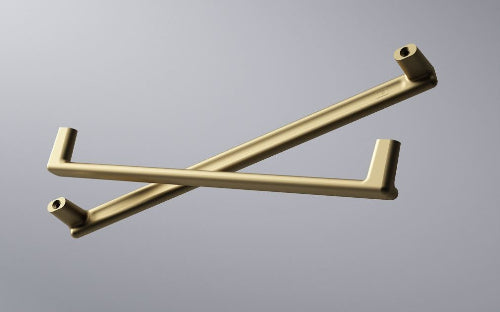 Two gold metal handles on a gray background
