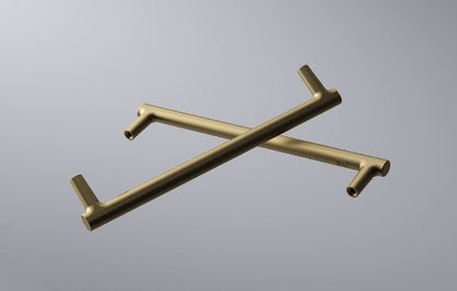 Two gold kitchen towel racks crossed on a gray background