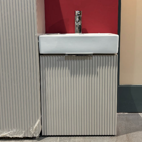 White sink with metallic faucet against a red and gray wall