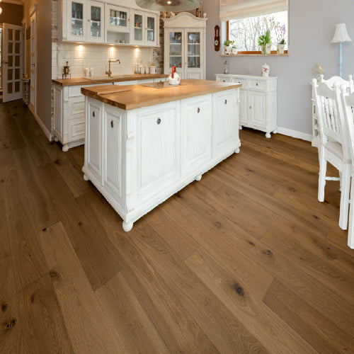 Kitchen with white cabinets, wooden island, and dining area.