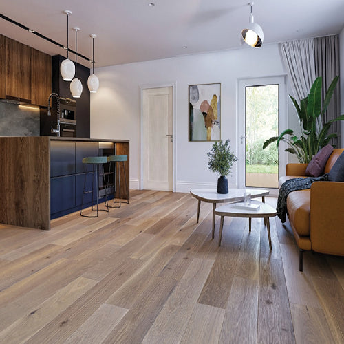 Modern living room with wooden flooring, kitchen, and decor elements.