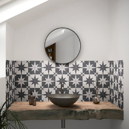 Bathroom with star-patterned tiles, round mirror, and wooden vanity.