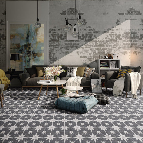 Modern living room with grey sofa, patterned rug, and abstract art on brick wall.