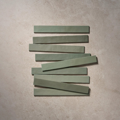 Nine green rectangular tiles arranged in a staggered pattern on a beige surface.