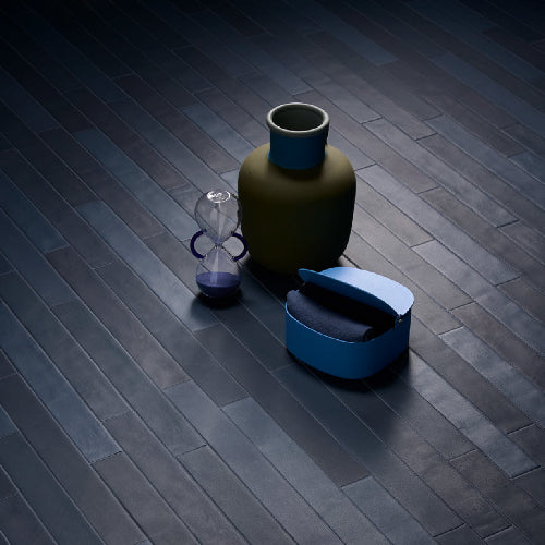 Vase and hourglass on a dark wooden floor