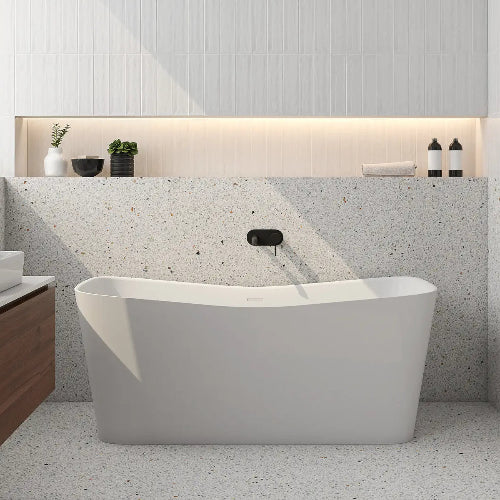 Modern bathroom with a freestanding bathtub against a textured wall.