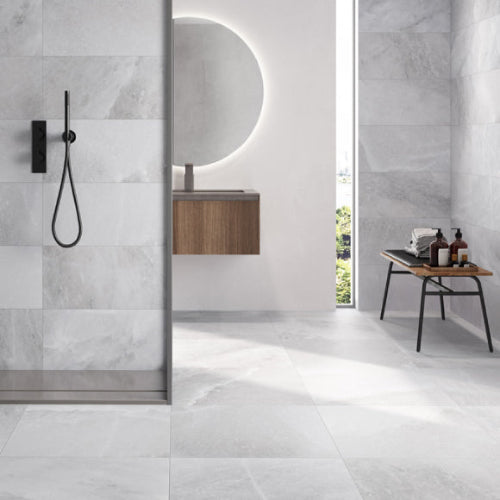 A modern bathroom setting featuring large format porcelain tiles with a granite effect, predominantly in gray tones.